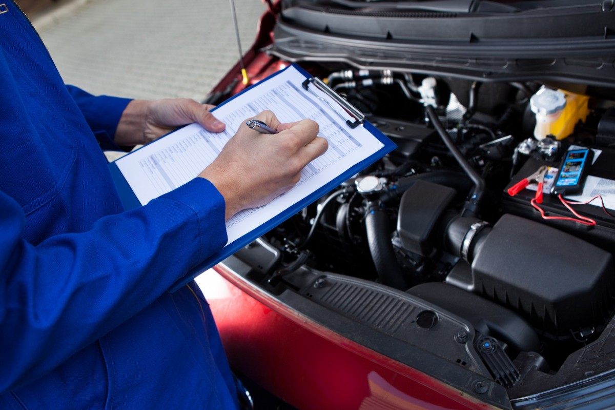 mechanic checking a list on a clipboard